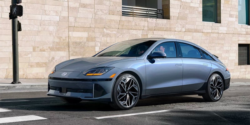 Silver electric sedan parked outdoors angled front view