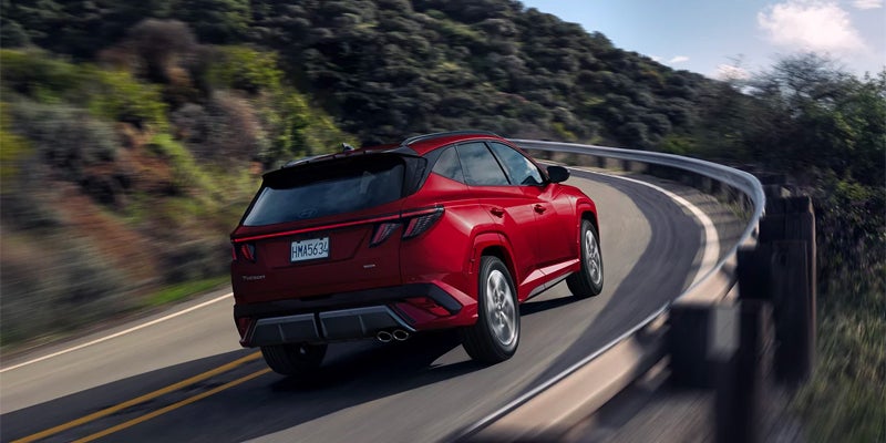 Hyundai Tucson SUV rear three-quarter view driving on mountain road